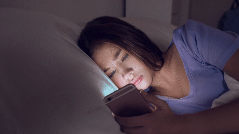 Photo of a teen girl using her phone in bed.